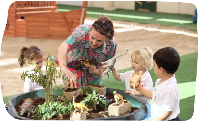 Nursery-aged children exploring small world play with a teacher at Step By Step Nursery Dubai, fostering imagination and creativity.