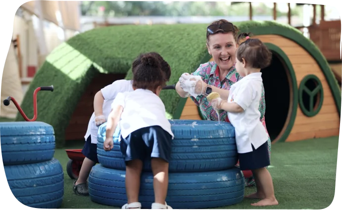 Toddlers enjoying an outdoor play activity at Step by Step Nursery Dubai, building gross motor skills and teamwork.