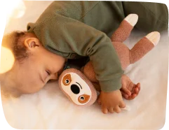 A baby peacefully hugging a plush toy during nap time, with Step By Step Nursery Dubai promoting healthy sleep routines for young children.